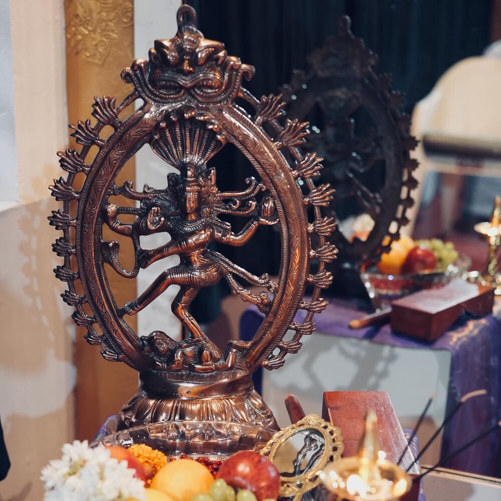 A Nataraja idol with offerings and a lit lamp